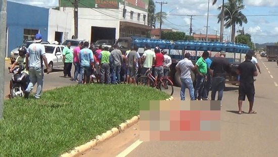 Motociclista fica embaixo de caminhão após colisão em retorno 