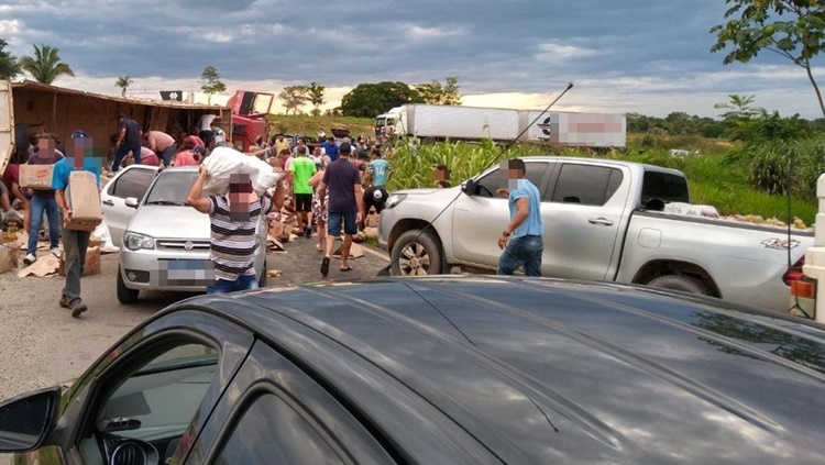 NA ROTATÓRIA: Caminhão carregado com óleo tomba e moradores saqueiam carga